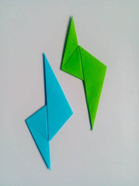 Beyaz arkaplanda mavi ve yeşil yıldırım origamisi izole edildi.