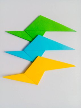 Sarı, mavi ve yeşil yıldırım origamisi beyaz arkaplanda izole edildi.