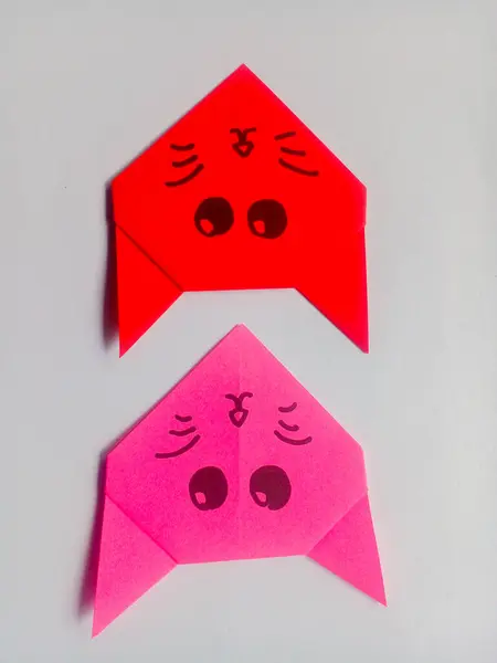 Origami kırmızı ve pembe kedi kafası beyaz arkaplanda izole edilmiş..