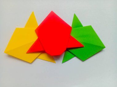 Sarı, kırmızı ve yeşil uçak origamisi beyaz arkaplanda izole edildi.