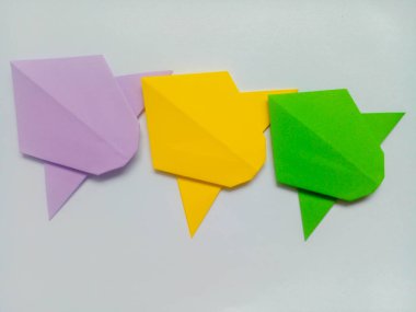 Mor, sarı ve yeşil uçak origamisi beyaz arkaplanda izole edildi.