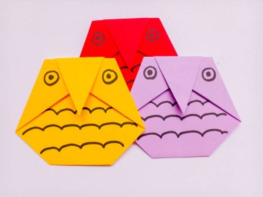 Beyaz arkaplanda sarı, kırmızı ve mor baykuş origamisi izole edildi.