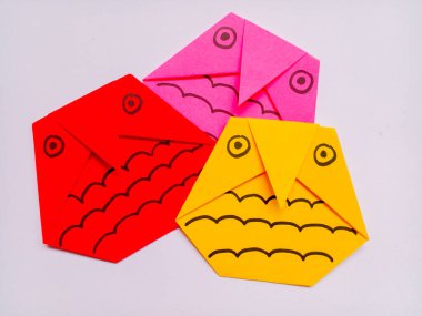 Beyaz arkaplanda kırmızı, pembe ve sarı baykuş origamisi izole edildi.
