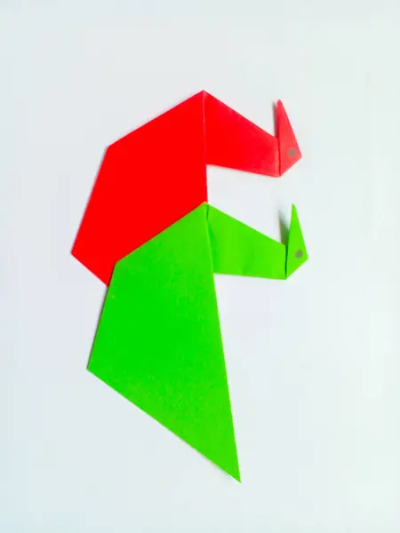 Beyaz arkaplanda yeşil ve kırmızı kuğu origamisi izole edildi.