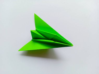 Yeşil uçak origamisi beyaz arkaplanda izole edildi.