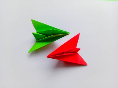 Yeşil ve kırmızı uçak origamisi beyaz arkaplanda izole edildi.