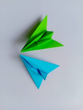 Yeşil ve mavi düzlem origamisi beyaz arkaplanda izole edildi.