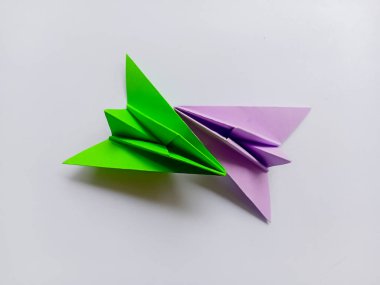 Beyaz arkaplanda yeşil ve mor renkli origami izole edildi.