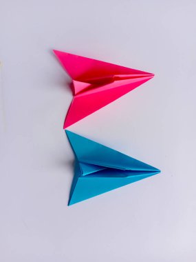 Pembe ve mavi düzlem origamisi beyaz arkaplanda izole edildi.