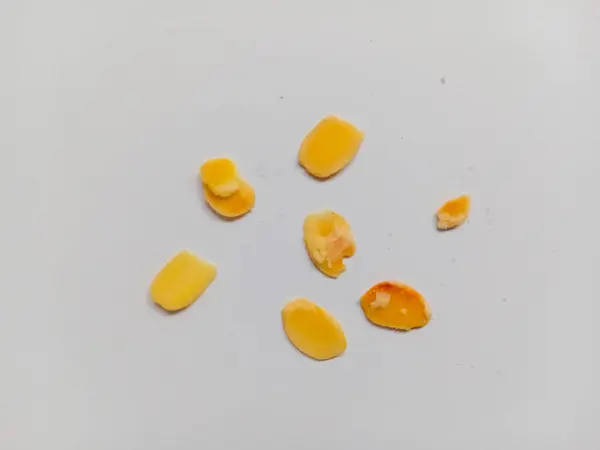 Dilimlenmiş bademler beyaz arkaplanda izole edilmiş.