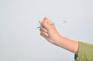 Beyaz arka planda izole edilmiş bir kalem tutan çocuk eli..