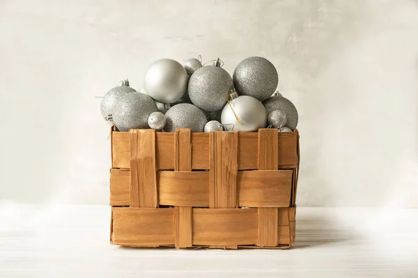A box woven from the bark with Christmas tree decorations, silver balls on a white light background.