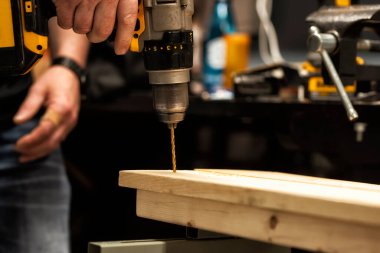 Male rough hands at work with drill tools. Hand labor. Selective focus, an image with a shallow depth of field.