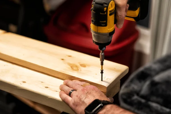 Male rough hands at work with drill tools. Hand labor. Selective focus, an image with a shallow depth of field.
