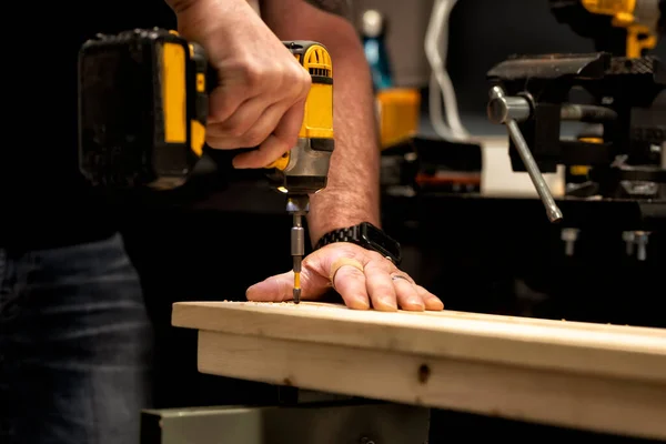 Male rough hands at work with drill tools. Hand labor. Selective focus, an image with a shallow depth of field.