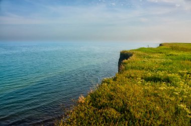 Green cliff on the seashore. Field and blue sea. Wild shores. Odessa region