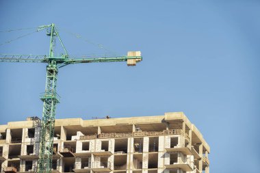 Çok katlı bir binanın inşaatı. Çak bakalım. Son katların beton blokları ve çatıdaki işçiler..