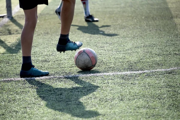 Futbol oyuncularının bacakları ve futbol sahasındaki top. seçici odak