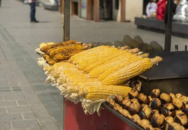 Bir şehir caddesinde kavrulmuş mısır ve kestane tepsisi. Geleneksel sokak ticareti İstanbul. Türkiye.