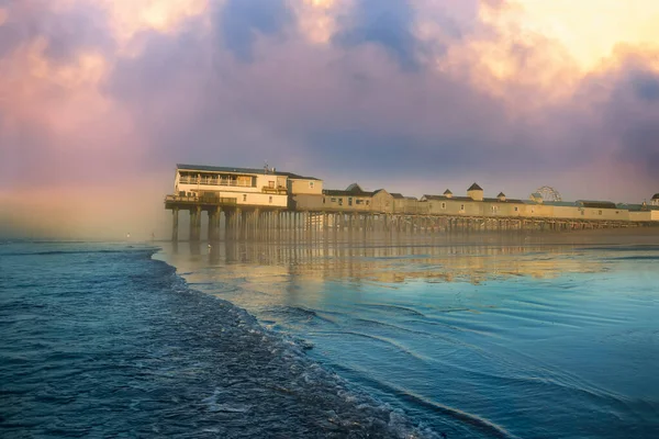 stock image Pier in fog at dawn. A famous place on the coast of the Atlantic Ocean. Old pier. USA. Maine. Old Orchard Beach.