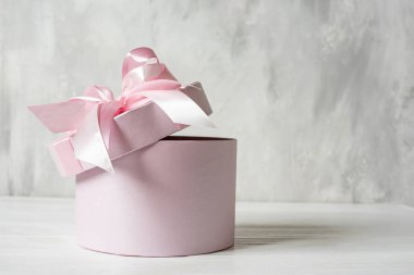  pembe bir karton kutu üzerinde pembe kurdele var.