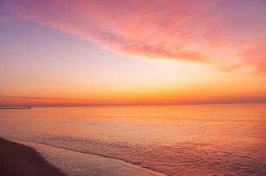 Güneşin doğuşunda güzel renkli deniz manzarası. Denizin sakin genişliği.