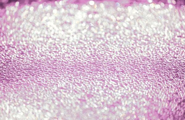 Abstract pink sparkling and sparkling droplets out of focus.