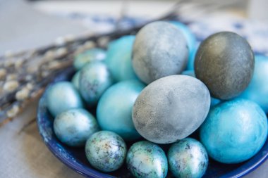 Paskalya 'da hayat devam ediyor. İnci gibi boyanmış mermer yumurtalar ve söğüt dalları. Fotoğraf: Gri-mavi tonlarda.