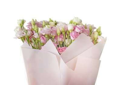 Bir buket pembe ve beyaz östoma lisianthus çiçeği pembe kağıtta. İzole et.