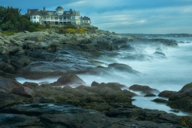 Atlantik Okyanusu kıyısında. City York, ABD, Main sahildeki evler ve taşların arasında dalgalar. Uzun pozlama.