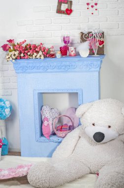 Dekoratif şöminesi, oyuncakları ve beyaz kutup ayısı olan şirin bir çocuk odası..