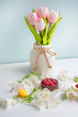 Çiçeklerle, kurabiyelerle ve pastalarla dolu bahar arkaplanı. Narin ışık yayları