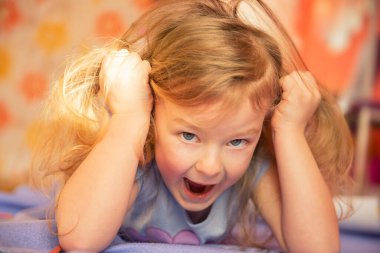 Sevimli, kızıl saçlı, neşe dolu yüzüyle başımı okşayan bir kız. Yüzü yakın plan. Evde eğitim. Samimi çocukluk duyguları gerçektir.. 