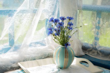 Bir buket kır çiçeği, çiçek, pencerenin yanındaki eski verandadaki vazoda. Retro Provence biçimi.