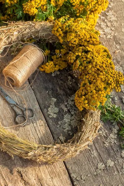 stock image a wreath of tansy flowers on a wooden rough background.rustic style. Handmade floral decor.