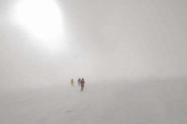 Dağlarda şiddetli bir kar fırtınası ve karanlığa doğru yürüyen bir grup turist. Tehlikeli kış aktif dinlenme.