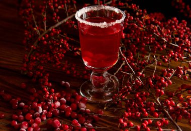 Yabanmersini suyu, böğürtlen şarabı ve kızılcık iç. Ahşap bir arka planda gösterişsiz siyah bir fotoğraf.