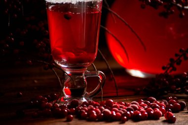 Yabanmersini suyu, böğürtlen şarabı ve kızılcık iç. Ahşap bir arka planda gösterişsiz siyah bir fotoğraf.