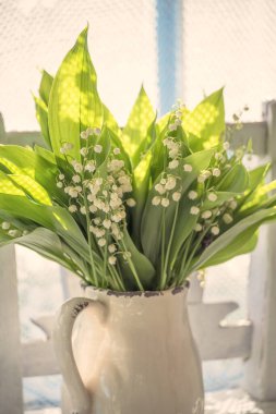 Bahar çiçekleri, pencerenin yanındaki seramik sürahide vadideki zambaklar. country style, provence, vintage