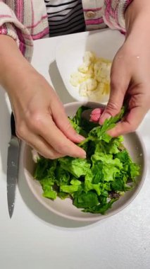 Yapraklı yeşil salata yapan kız elleri pancar kökü ve karnabahar yakın plan. gerçek sahnelenmemiş basit ev ortamı