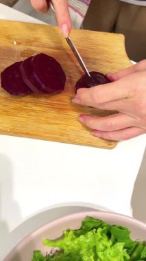 Yapraklı yeşil salata yapan kız elleri pancar kökü ve karnabahar yakın plan. gerçek sahnelenmemiş basit ev ortamı