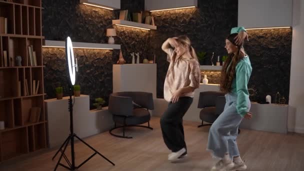 漂亮少女跳舞的侧视图 并为社交媒体录制视频 两名年轻漂亮的女子在网上跳嘻哈流行舞 在家里玩得很开心 高质量的镜头 — 图库视频影像