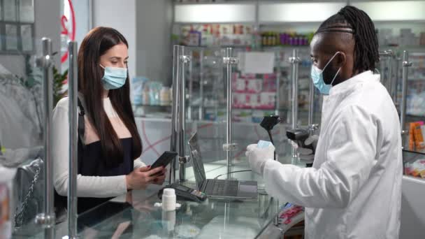 Junge Kundin Schutzmaske Bezahlt Mit Ihrem Smartphone Problemlos Medikamente Nachdem Stock-Filmmaterial