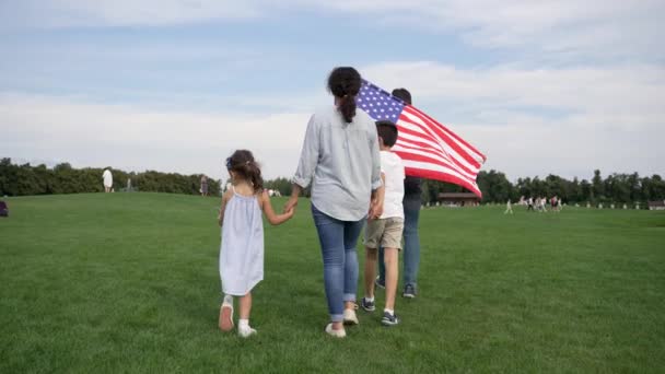Woman Walking Two Children Grassy Meadow Holding American Flag Cloudy Stock Video