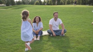 Yaz boyunca yeşil bir parkta eğlenen farklı bir aile neşe ve bağları paylaşıyor. Kaygısız bir birliktelik anı.