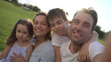 Çok kültürlü bir aile parkta özçekim fotoğrafları çekiyor, özel anılar yaratıyor ve birbirleriyle olan bağlarını güçlendiriyor. 4k
