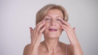 Cilt bakımı sırasında yaşlanan güzel bir kadının portresi. Krem sürerek ve parmak vurarak mutlu bir kadın olduğunu varsayıyorum. Zarif yaşlanma