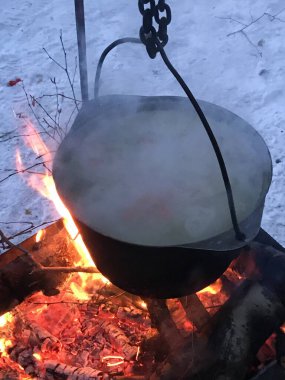 Soğuk kışta kazan ateşin üzerinde duruyor. Seyahat ve turizm.