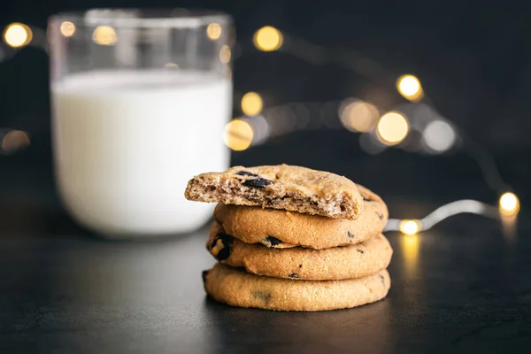 ブラックを基調としたブラックを基調としたチョコレートチップクッキーとミルクのグラス デザート ベーキング 甘い食べ物の概念 — ストック写真