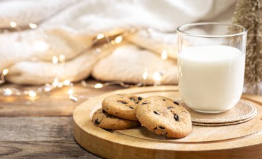 Çikolata parçalı kurabiyeler ve Noel Baba için bir bardak süt. Kış tatilini kutluyoruz, boşluğu kopyalıyoruz.